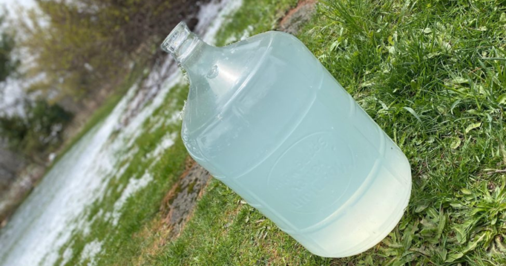 A picture of a giant glass bottle filled with spring water to show the health benefits of spring water