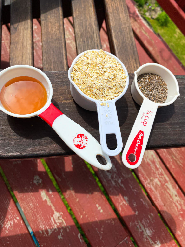 A picture of oats, honey, and chia seeds in measuring cups. 