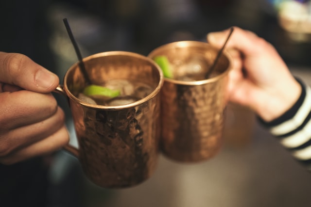 A picture of two people clinking glasses together as a toast in order to represent successfully socializing when dieting.