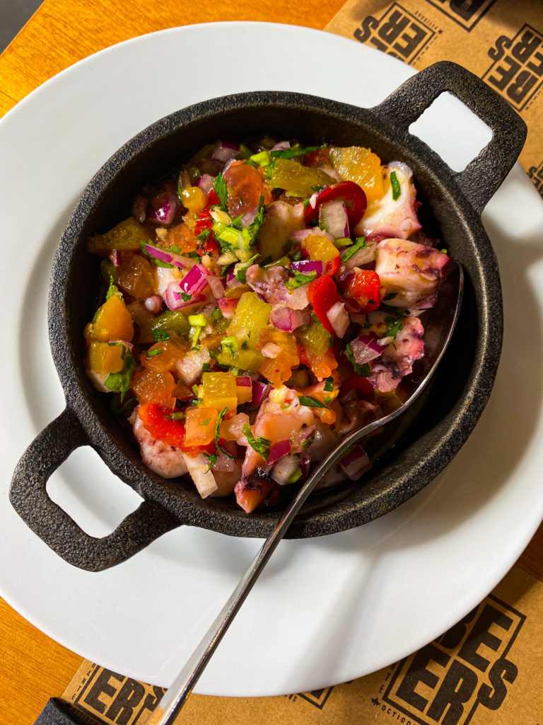 A homemade octopus salad that was made in the kitchen of an Airbnb