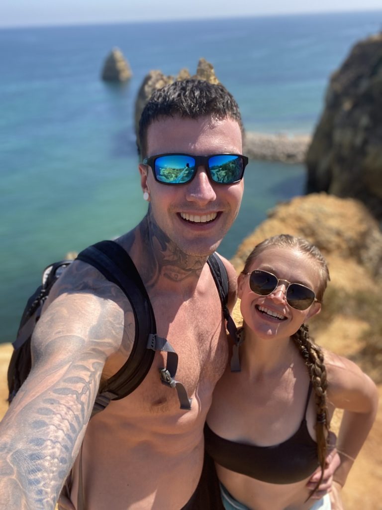 A picture of my girlfriend and I in Portugal standing next to some cliffs in the Algarve region