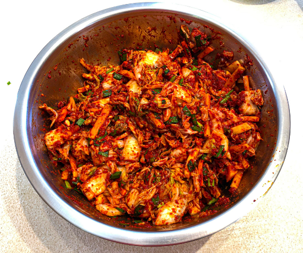 A picture of the kimchi all mixed up in a big bowl