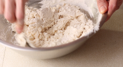 Flatbread flour being mixed in a stainless steel mixing bowl.