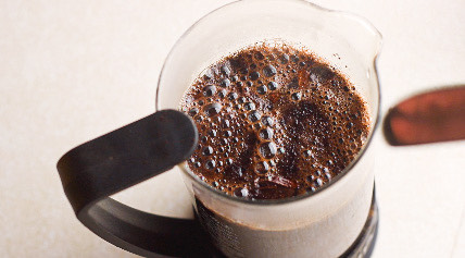 Flavor packed coffee with bubbles coming to the surface in a french press that contains black cardamom and cassia. This helps you stick to your diet.