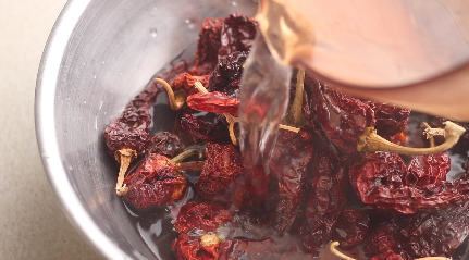 Dried Kashmiri peppers being rehydrated with boiling water.