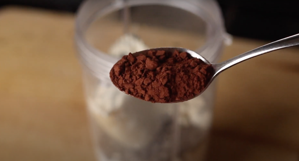 A teaspoon of cocao powder on a metal teaspoon