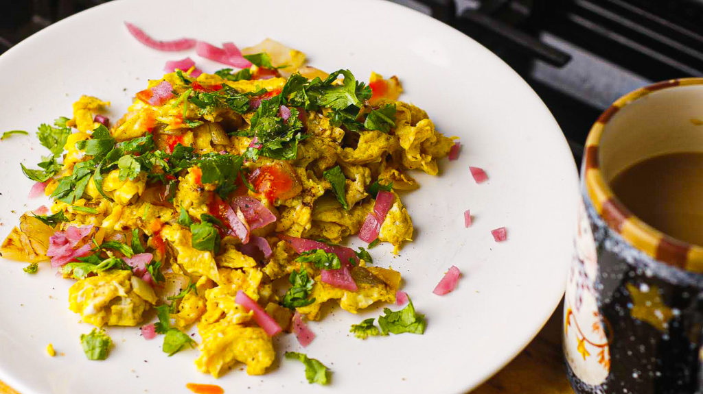 A picture of a recipe with layers of flavor to help you stick to your diet. Eggs on the bottom, pickled onions and cilantro on top all served with a side of flavor packed coffee