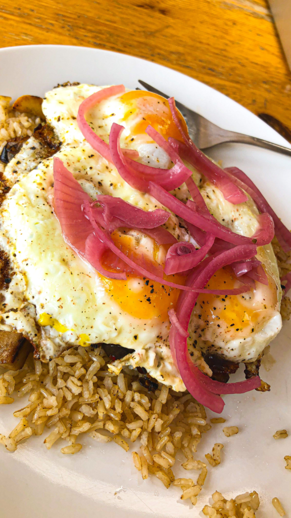 A healthy meal of eggs and brown rice rice topped with pickled onions. This meal is high in protein and volume and lets you increase your energy levels.