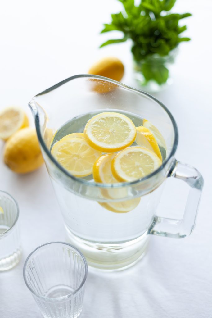 a picture of a pitcher of water with lemon for getting in shape again.