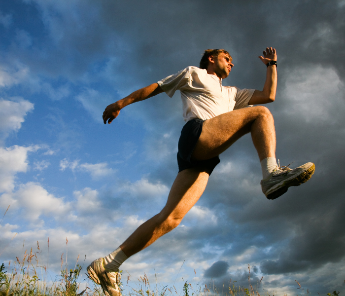 A runner leaping through a field.