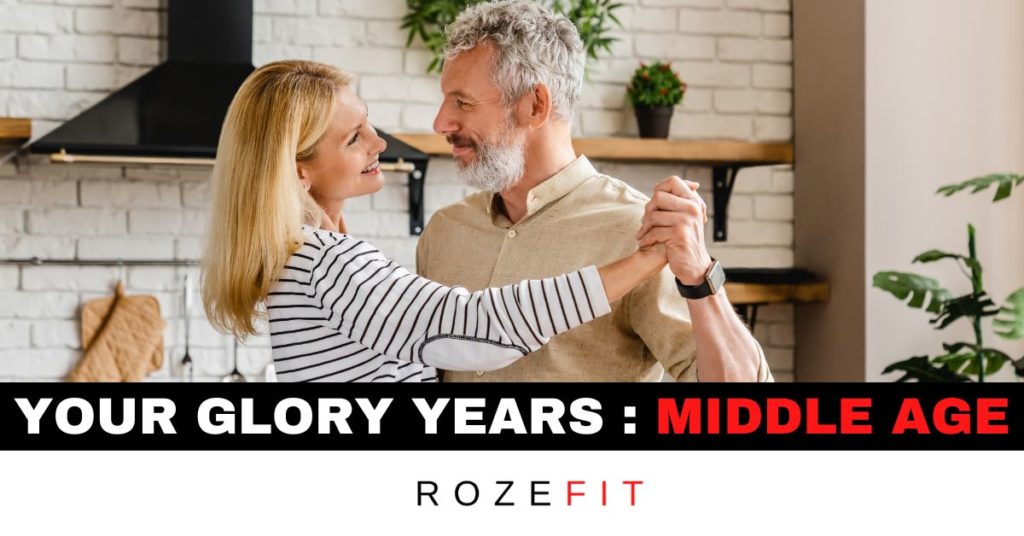 A middle-aged couple dancing in the kitchen with text that reads "your glory years, middle age".