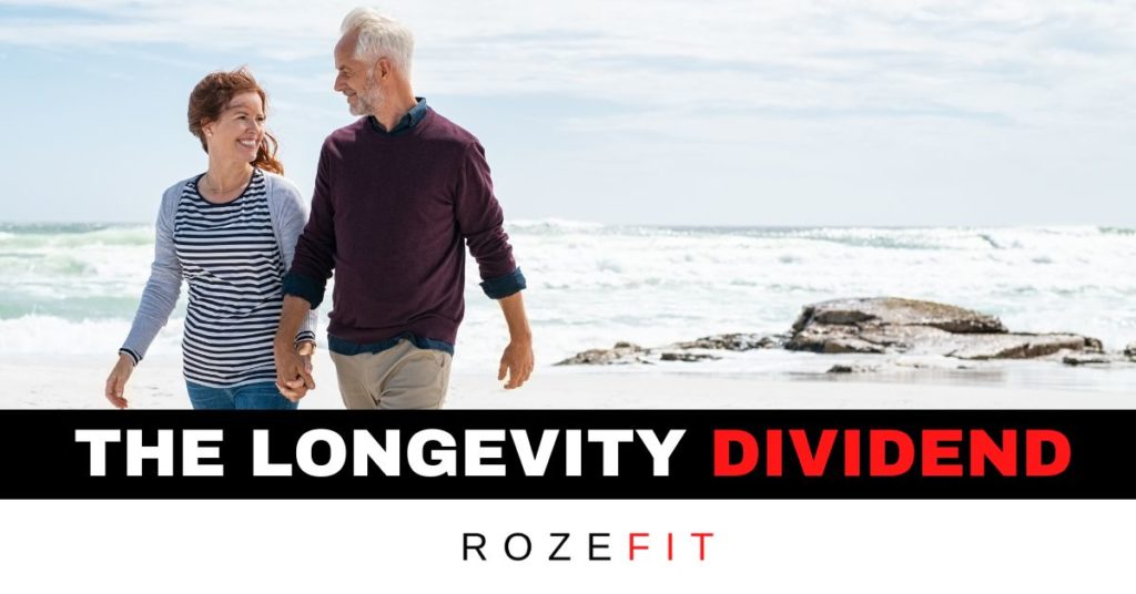 A middle-aged couple walking on the beach holding hands with text underneath that reads "the longevity dividend"
