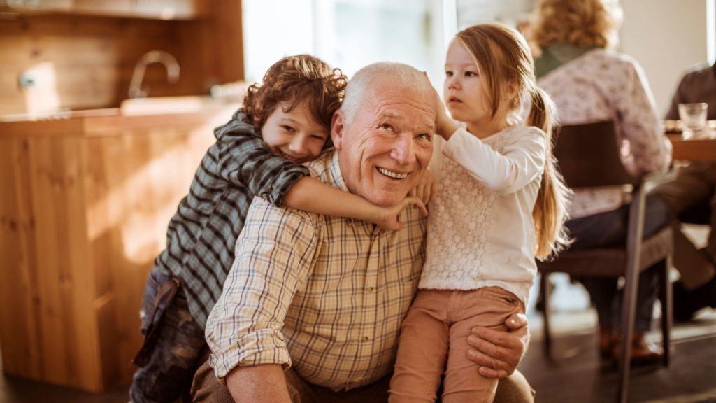 A grandfather playing with his grandkids.